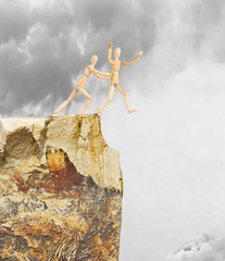 One person pushes another from a high cliff. Abstract image with wooden puppets