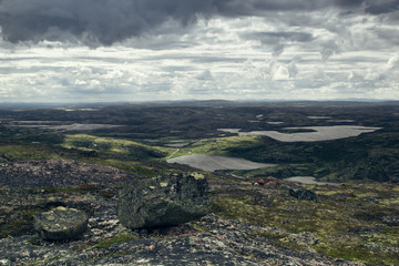 Fototapeta na wymiar Highlands valley with views of the lake and the green hills in a sunny cloudy day. Arctic summer, the tundra, Norway.