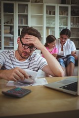 Worried man calculating bills while his wife wwwwwwwwwwwwwww