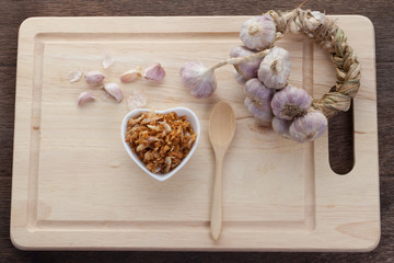 Thailand garlic on a wooden cutting board and deep fried garlic