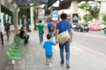 Father and son walking along a footpath in a traffic jam, Blur