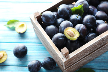 Tasty and ripe plums on blue wooden table