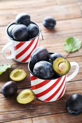 Tasty and ripe plums on brown wooden table