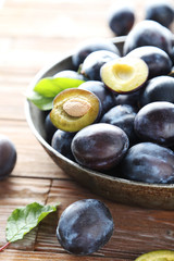 Tasty and ripe plums on brown wooden table