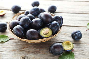 Tasty and ripe plums on grey wooden table