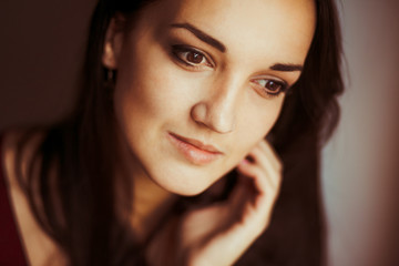 Fototapeta premium Light smile shines over woman's face while she looks nowhere wit