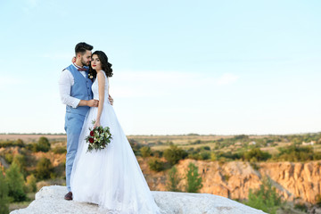 Fototapeta na wymiar Bride and groom standing over beautiful landscape