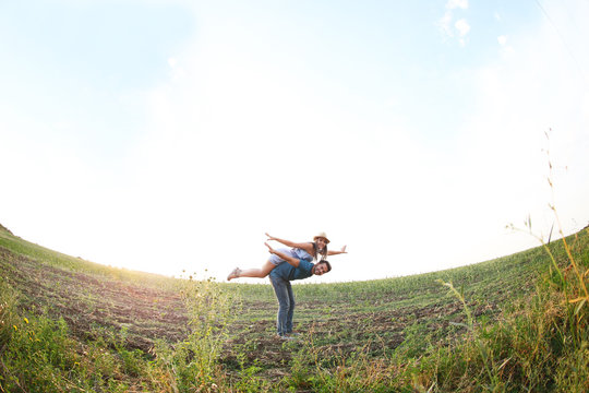 Young couple in love having fun on the meadow