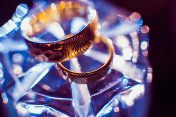 Fototapeta na wymiar Light reflects in the bottom of glass where the wedding rings li