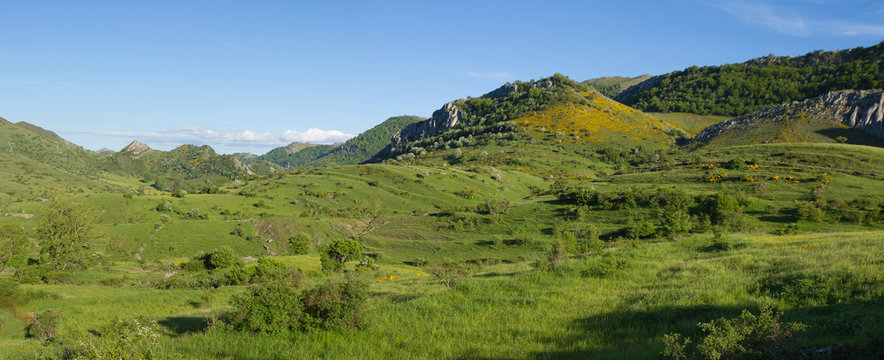 Vista panoramica de paisaje monta&ntilde;oso con bosques, picos y colinas recubiertos de  hierba verde en primavera,