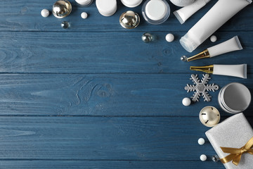Beauty cosmetic products with Christmas decoration and gift on blue wooden background