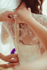Women button up pearls on bride's dress