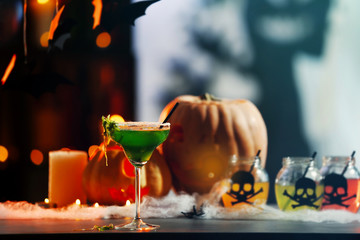 Glass with tasty cocktail for Halloween party, on blurred background