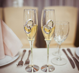 Newlyweds' wedding flutes with a decorative wedding rings on the