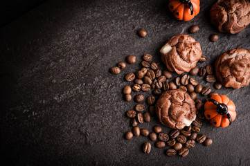 Eclairs and coffee beans with halloween decoration on black background