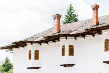White building with closed windows shutters.