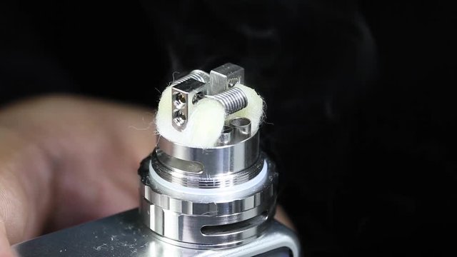 showing burn of e juice or e liquid in new dual kanthal micro coils and organic cotton on atomizer’s deck base of electronic cigarette for vaping, close up scene, high definition, Full HD, 1920x1080