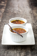 Traditional French creme brulee dessert with caramelized sugar on top, on wooden table

