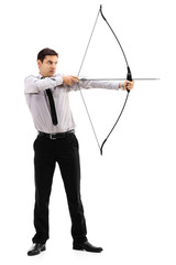 Young businessman aiming with a bow and arrow