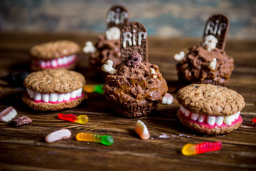 Dentures for Halloween made of cookies and marshmallow and Halloween cupcakes with tombstone
