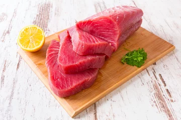 Fototapeten Raw tuna steak on wooden cutboard © Patryk Kosmider