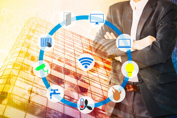 Smart Building and Internet of Things concept. Smart building management icons on Double exposure of Business man, office building and abstracy digital connection background.