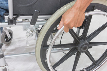 Close-up of male hand on wheel of wheelchair