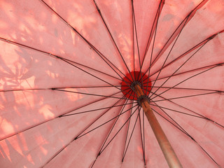 Old red umbrella with shadow