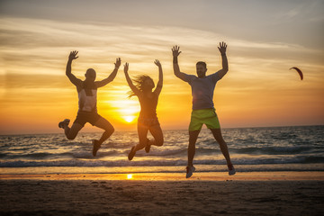 Fitness people at the beach, jumping.