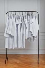 Medical clothes in row on floor hanger.