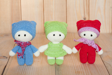 Three variegated crochet soft toys on a wooden background