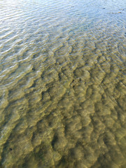 Abstract background of ripples on water surface on sea shore. Beautiful natural abstract background. It's crystal clear see through