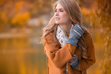 Young beautiful blondie woman in the autumn park