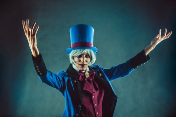 Smiling circus actor in blue tuxedo is presenting something. - obrazy, fototapety, plakaty