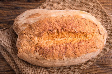 Fresh bread top view on rustic wood background.