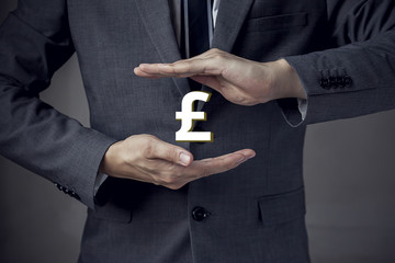 3D UK Pound sterling currency sign in between two hands of business man