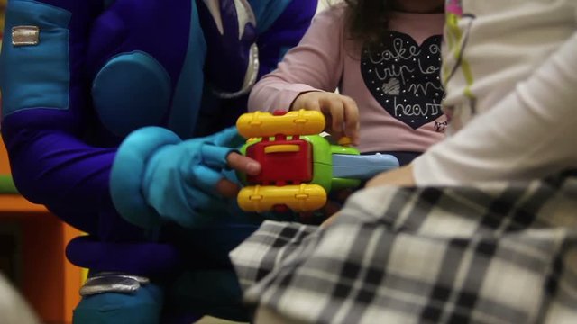 animator with children collect toy plane from constructor