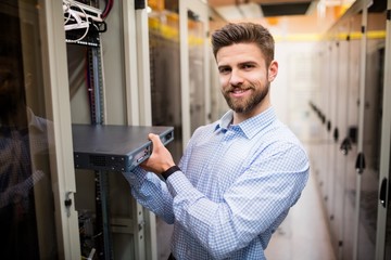 Technician removing server from rack mounted server