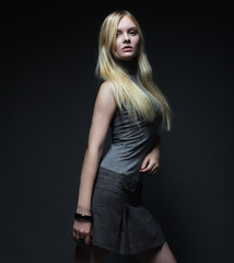 Fototapeta premium Portrait of beautiful young blonde girl in black dress. 