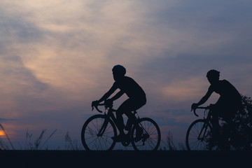 Fototapeta premium Silhouette cyclists at sunset