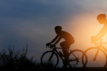 Fototapeta na wymiar Silhouette cyclists at sunset