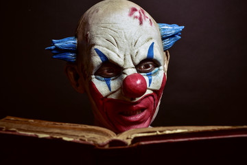 scary evil clown reading a book