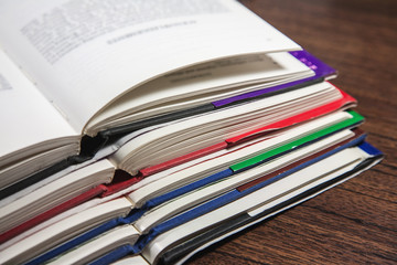 Stack of open books on wooden table