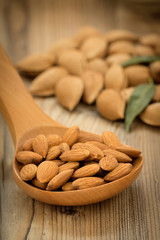 Almonds on brown wooden background