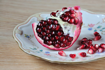 Piece of pomegranate on a porcelain plate. Кусочек граната на фарфоровой тарелке.