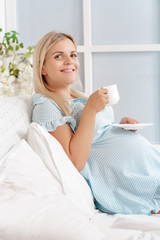 Obraz na płótnie Canvas young pregnant woman drinking tea
