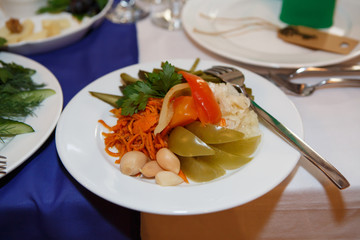 Pickled vegetables - garlic, carrots and peppers on the holiday table. Food vegetable on the plate. Cold snack lunch.