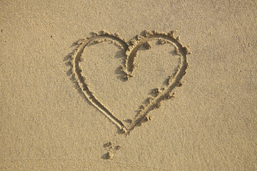 Obraz na płótnie Canvas Aerial view of a love heart drawn in wet sand on the beach