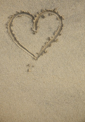 A heart hand drawn in the wet sand on the beach