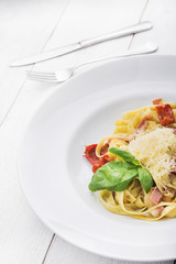 Italian pasta with sauce, bacon, tomato and parmesan